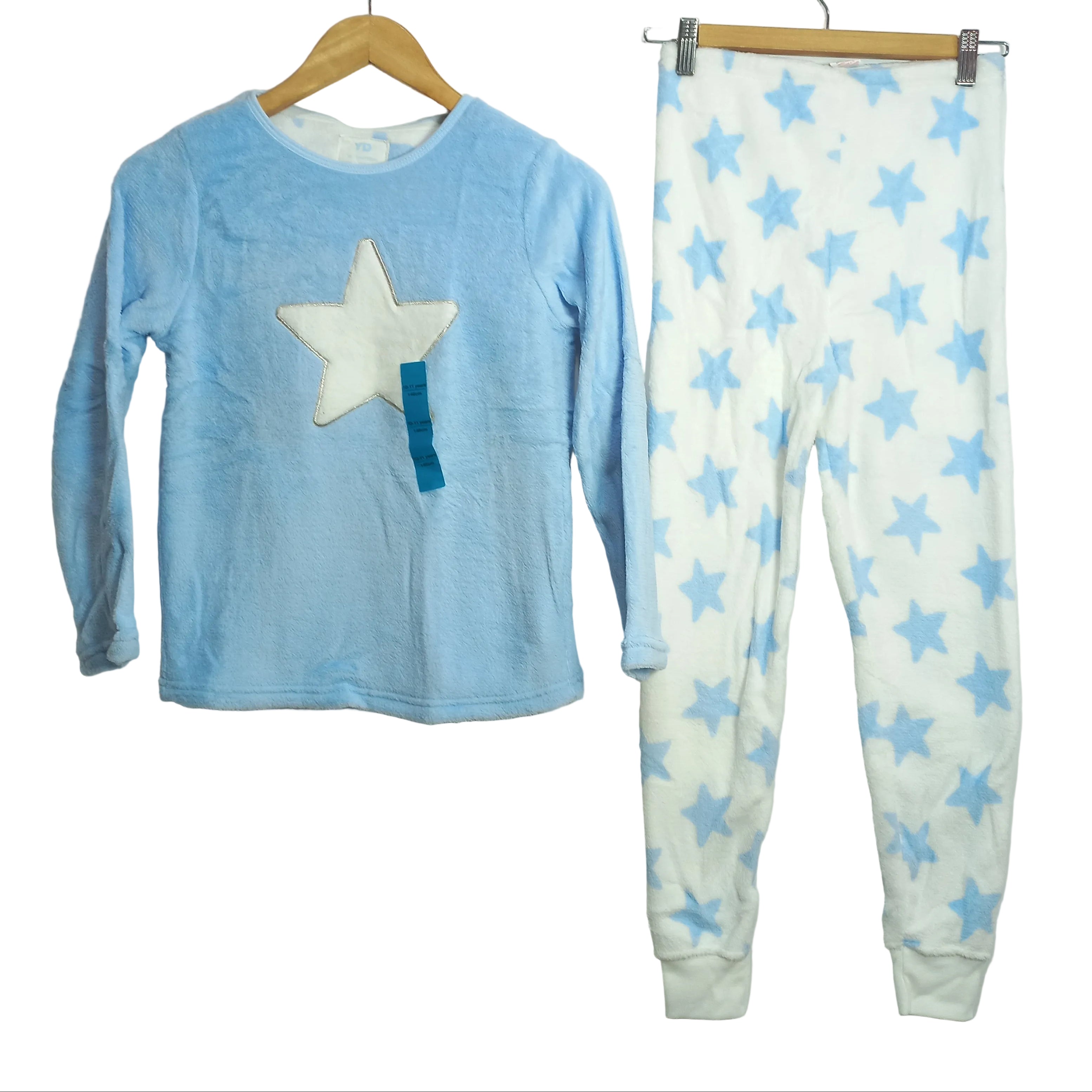 Children's outfit with star-patterned shirt and blue pants on a light gray background