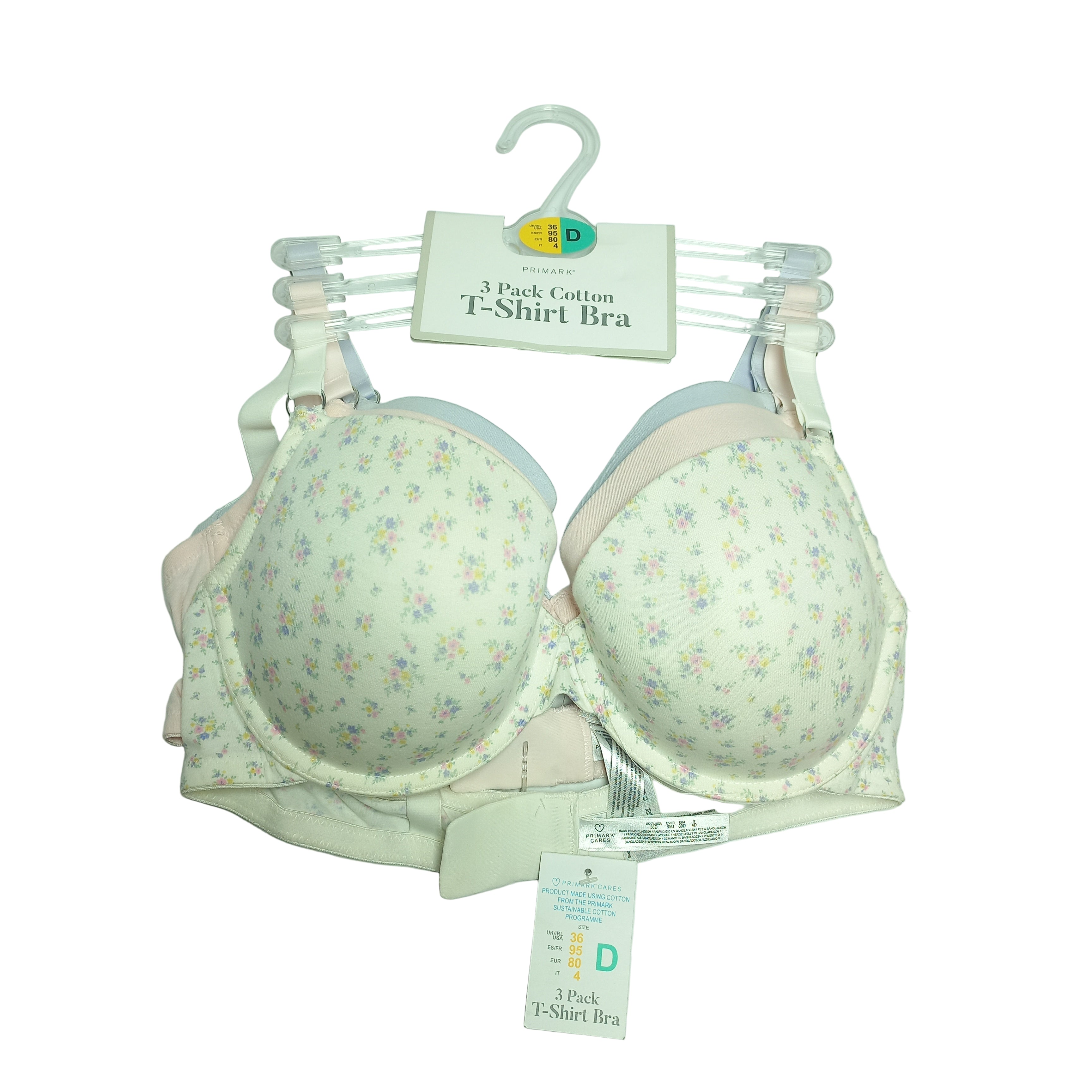 Set of three floral-patterned bras on hangers with visible tags on a white background