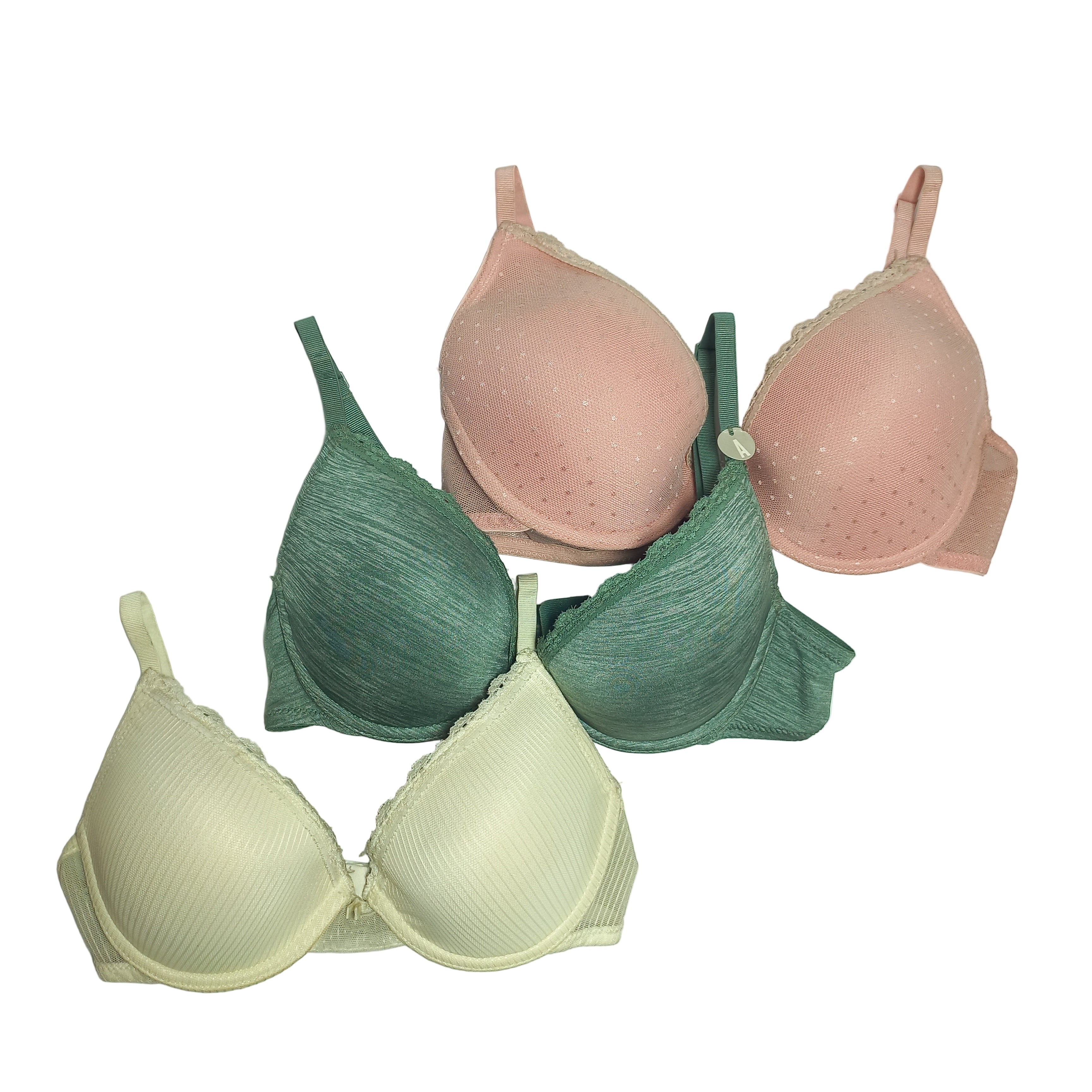 Three T-shirt bras in pink, green, and beige on a light gray background