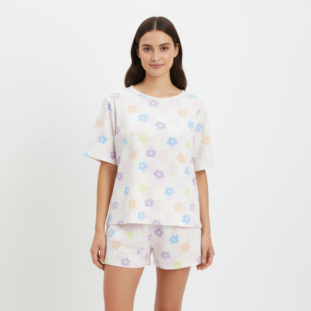 Woman wearing a white pajama set with colorful floral patterns 